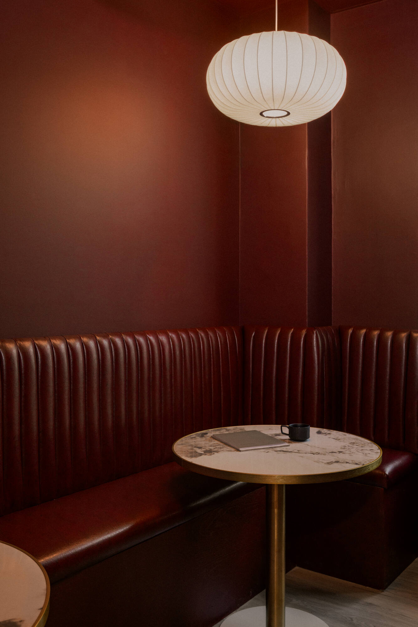 The Resident Lounge, the banquette and pendant light in warm light